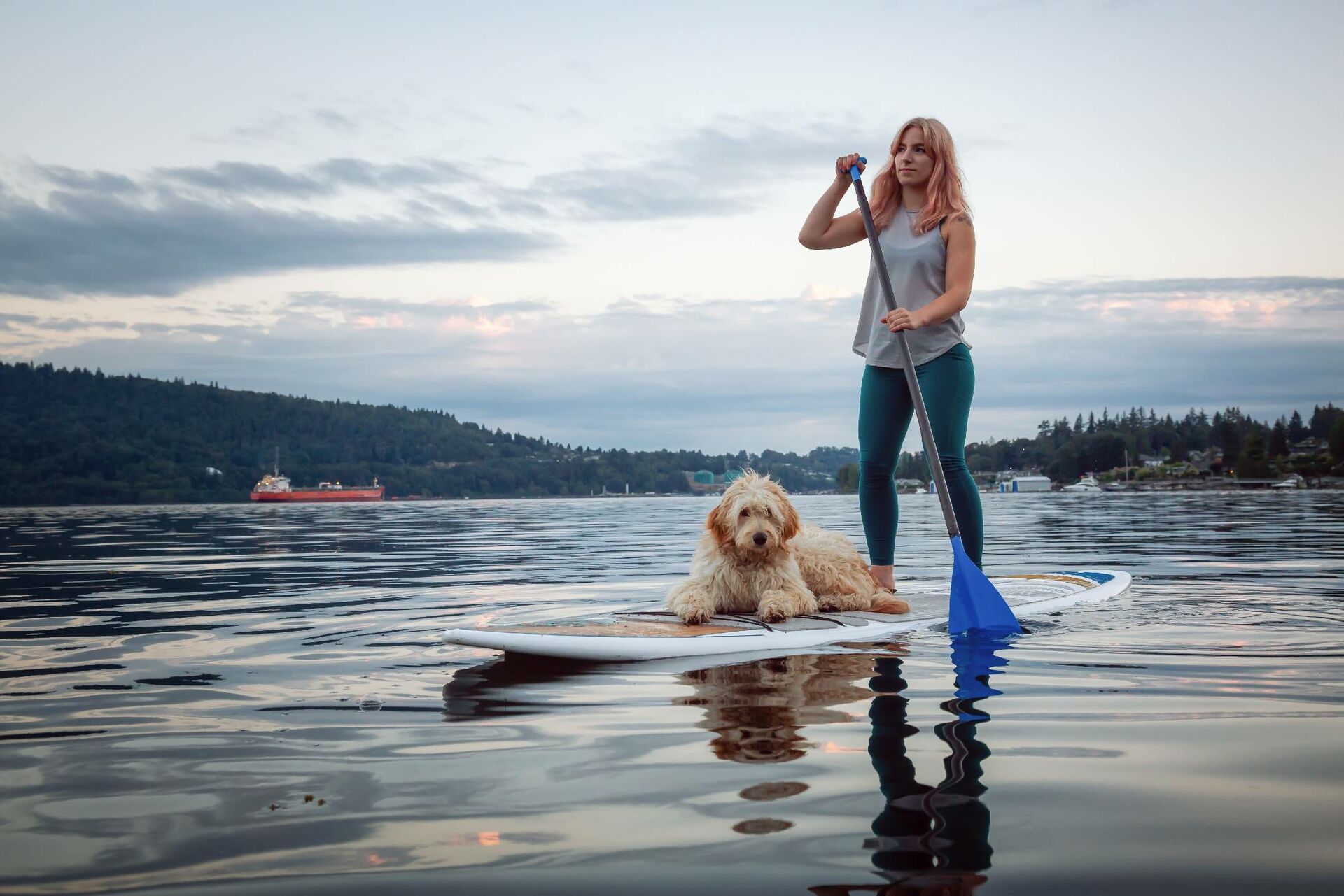 Frau mit ihrem Hund auf einem SUP Board.